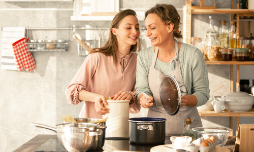 Imagem Ilustrativa: Mãe e filha felizes cozinhando